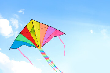 Colorful kite flying in blue sky on sunny day