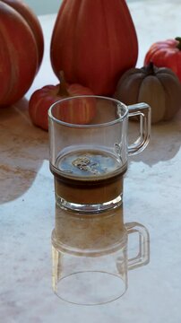 Making a Pumpkin Spice Latte. Pouring espresso, steamed milk, and whipped cream into a glass mug over pumpkin syrup. Autumn coffee preparation