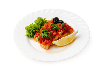 Delicious fish dish with tomato sauce and fresh herbs served with lemon and greens