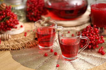 Cups of tasty viburnum tea on table in room, closeup