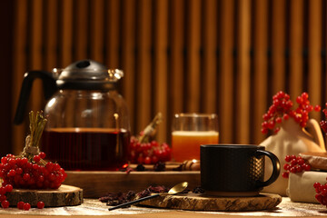 Cup of tasty viburnum tea on table in living room, closeup