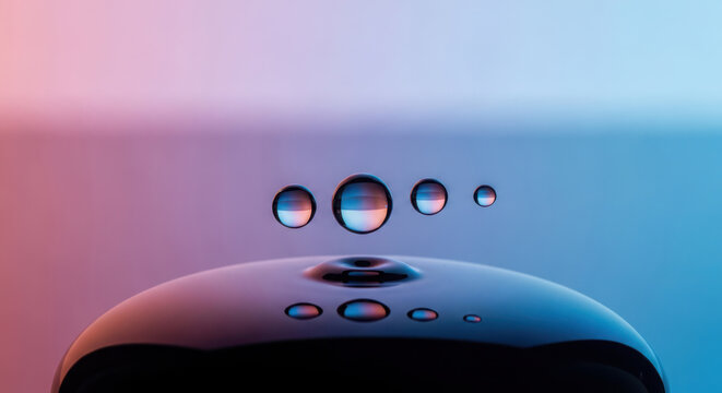 Water droplets suspended in air above a reflective surface