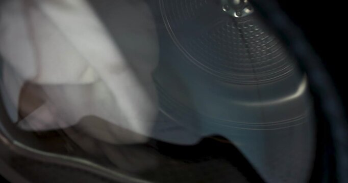 Close up inside view of modern tumble dryer drum spinning with motion blur. Abstract texture of clothes dryer machine working with laundry during cycle. Concept of Technology, Smart Home. 4k VDO