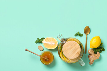 Composition with glass teapot of tasty fruit tea and ingredients on turquoise background