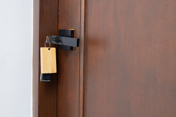 Close the woodendoor to a new home with key and home shaped keychain.