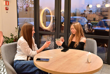 Women friends reunited at a cozy cafe, talking and enjoying beverages