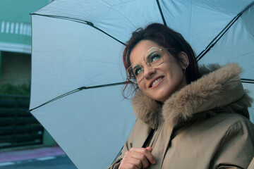 Smiling woman with umbrella on the street