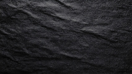 Fototapeta premium Dark wrinkled material with a textured surface and subtle highlights