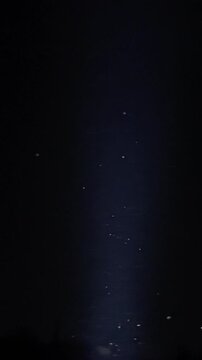 Dust particles float past dark blue background