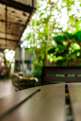A collection of wood table background shots taken in a bright outdoor cafe, featuring lush green scenery, natural textures, and a calm cozy atmosphere ideal for design, mockups, or workspace visuals.