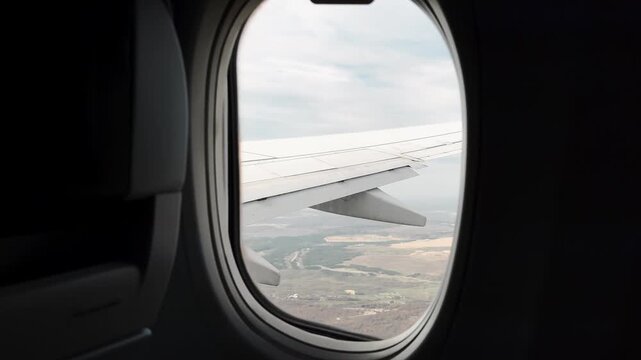 A plane flying high above the clouds.
A round airplane window on board.
Airplane window in a passenger plane.
Tourism, flight, aviation, transport, altitude