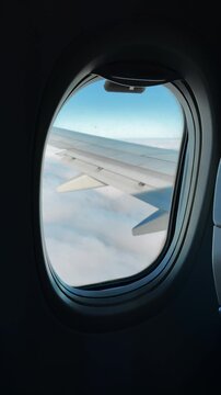 A view from the window of a flying airplane.
A round window in the cabin of a passenger plane.
Air transport for carrying passengers.
Transport, flying, airplane, window, sky, takeoff, airport