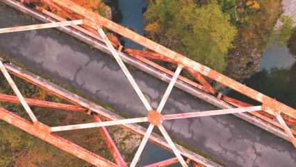 紅葉の渓谷にかかる赤い橋のドローン俯瞰ショット