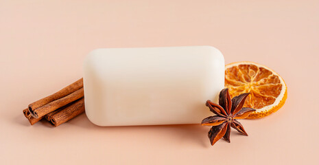One natural organic craft white bar of soap with cinnamon sticks, star anise, and dried orange fruit slice on pastel background used for skin and body care beauty treatment for spa relaxation hygiene