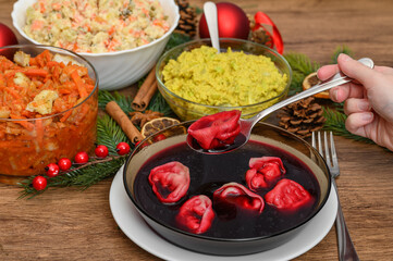 Christmas Eve meeting, eating borscht with dumplings, salads on the table