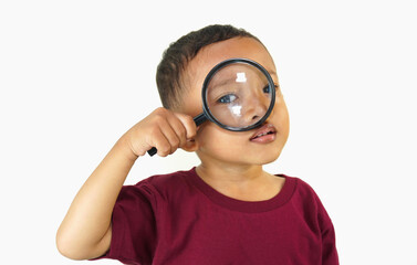 A 3 year old Asian boy is holding a black magnifying glass to his eye, trying to see an object with the magnifying glass, has a high level of curiosity, an expression of great curiosity