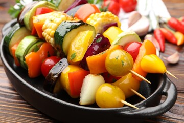 Skewers with tasty grilled vegetables on wooden table, closeup