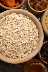 Making granola. Oat flakes, dried fruits and other ingredients on wooden table, flat lay