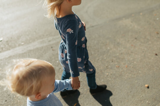 Siblings walking outdoors hand in hand creating connection