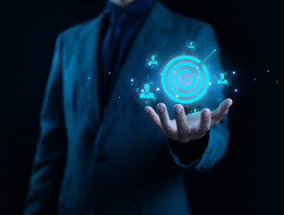 A business professional holding a glowing digital target icon symbolizes marketing strategy, customer targeting, precision, and business planning, ideal for concepts related to audience insight.