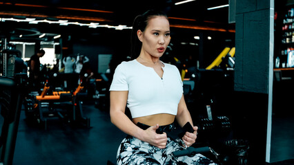 A woman is exercising on a fitness machine in the gym