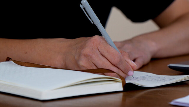 A person is writing in a notebook
