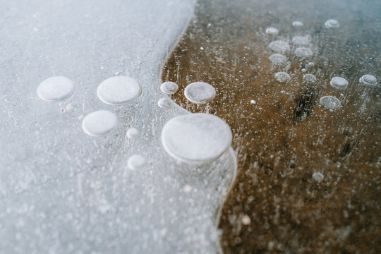 Gefrorene Luftblasen in einer Pf&uuml;tze
