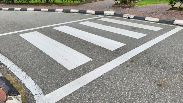 a zebra crossing, a type of crosswalk designed for pedestrians. It features broad white stripes painted on the road surface to indicate a designated crossing point. 