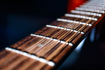 Fototapeta premium Close-up view of an acoustic guitar fretboard, showcasing strings with light brown and dark ends, arranged in parallel and equally spaced The warm wooden fretboard contrasts with the lighter strings