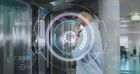 Man answering phone, tapping watch in business by elevator while HUD overlay expands, awaiting OK