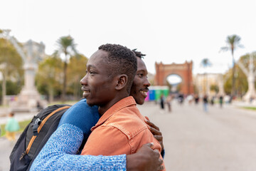 African American men embracing outdoors, enjoying travel and friendship in Barcelona