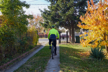 Obraz premium Old man exercising by riding a bicycle on a beautiful autumn day