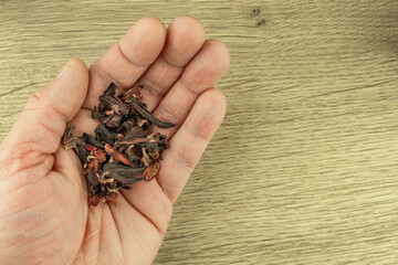 A man holds a hibiscus in his hand, oriental spices for tea
