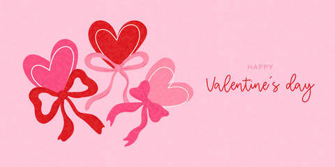 Three elegant heart symbols with decorative ribbons and bows on a pink background are perfect for a Valentine's Day card or any romantic occasion.