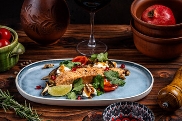 Salmon with roasted vegetables and herbs on rustic plate