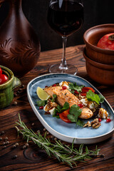 Grilled salmon with herbs and wine on rustic table