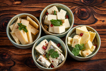Four varieties of hard cheese served in rustic bowls