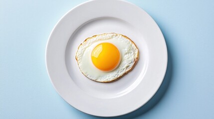 Single Fried Egg on Clean White Plate Centered on Light Blue Background