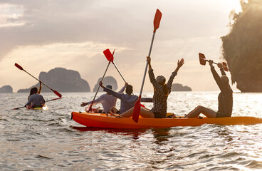 Big group of happy young friends are kayaking and having fun at sunset sea bay