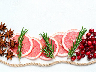 Sliced grapefruit with rosemary and cranberries on white background  
