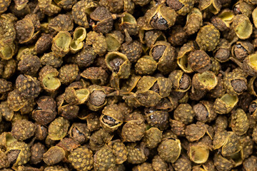 Pile of dried green szechuan peppercorns or chinese prickly for background. Top view
