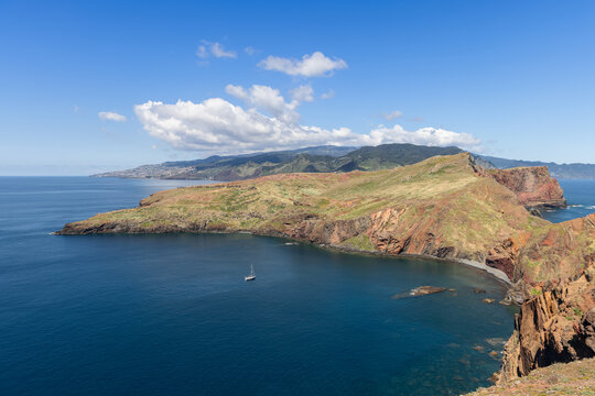 Ponta de Sao Lourenco Madeira coastal headland with rugged volcanic slopes and calm blue bay, shown from an elevated viewpoint that reveals layered rock surfaces