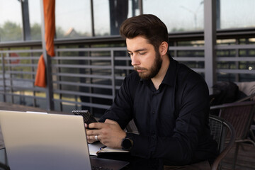 Man is sitting at a table outdoors or in a cafe setting