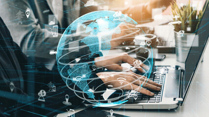 A business professional interacts with a laptop while a digital globe overlay illustrates global connectivity and innovation in technology-driven environments. Xenic