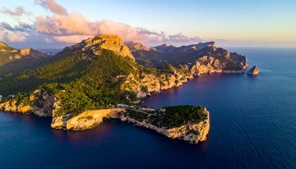 A coastline with rocky cliffs, lush trees, and calm blue ocean under a partly cloudy, brightly lit sky at sunset