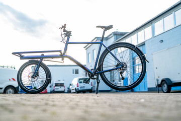 Electric Cargo Bike in Front of Industrial Building, Backlit Outdoor Urban Scene