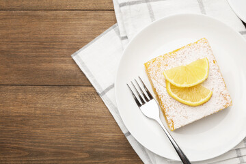 Tasty lemon bar with powdered sugar served on wooden table, flat lay. Space for text
