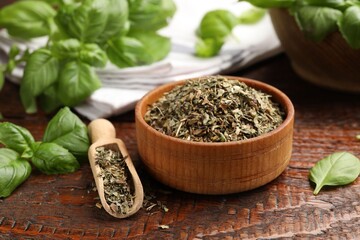 Dry basil leaves, fresh ones, bowl and scoop on wooden table, closeup