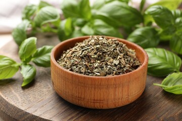 Dry basil leaves, fresh ones and bowl on table, closeup