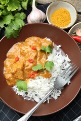 Chicken tikka masala with rice served on table, flat lay